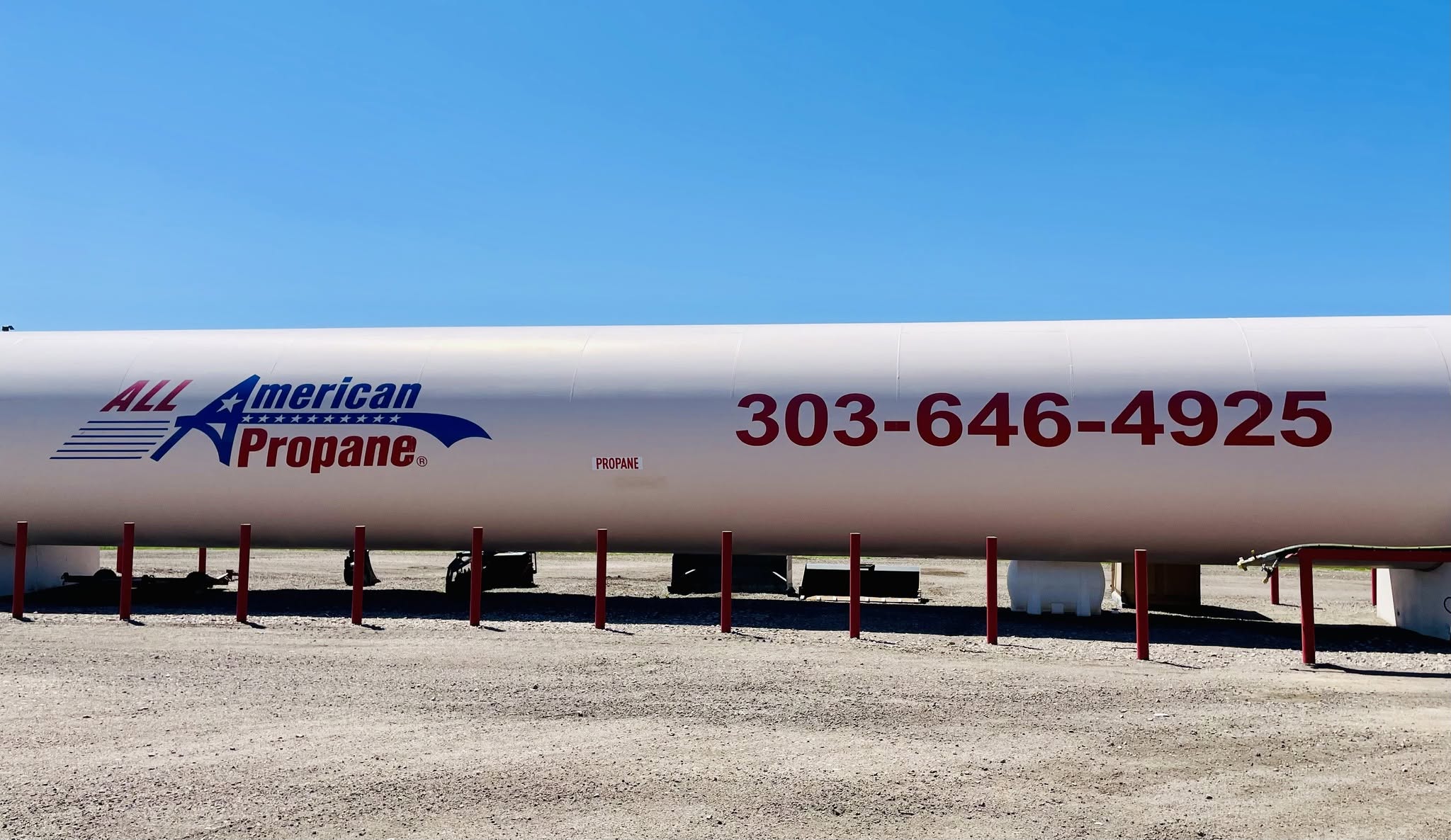 large propane tank with all american logo and phone number on the side